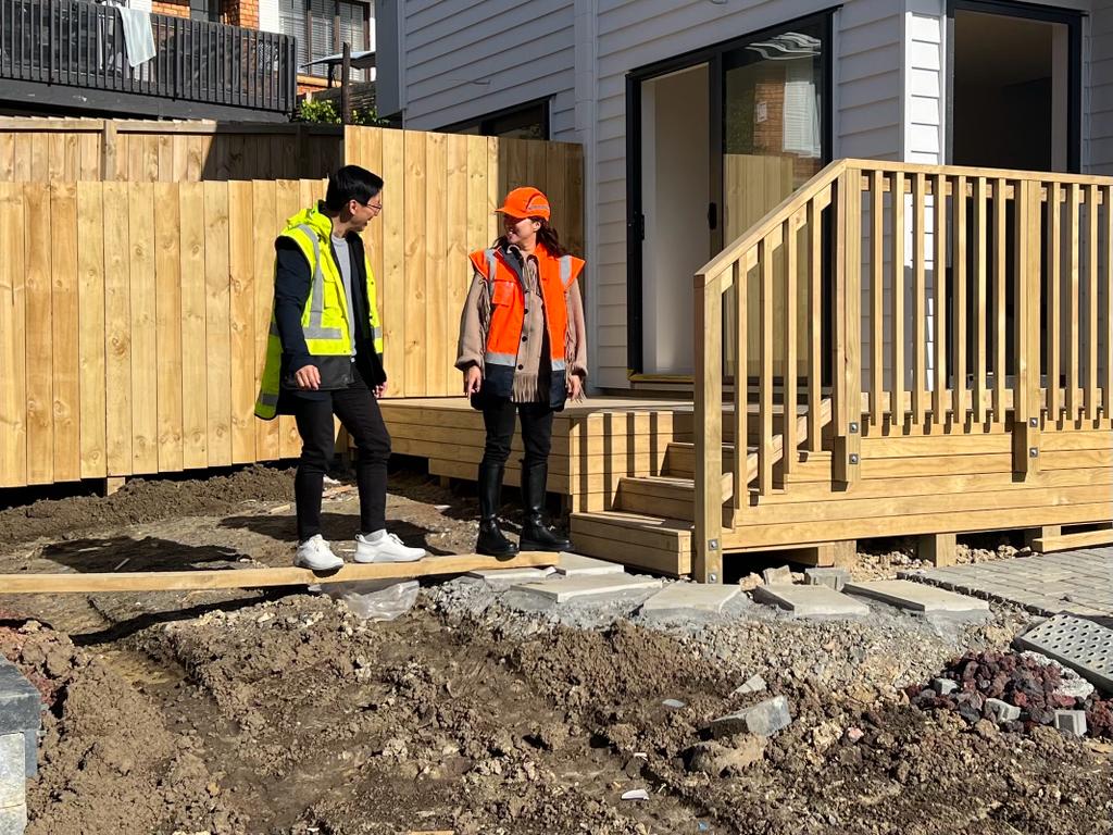 JR Finance Advisor and client at a home development site walking on mud and scafolding wood